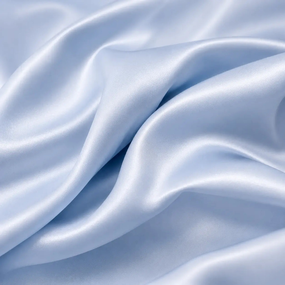 Gros plan sur le tissu rafraîchissant Marea bleu poudré, mettant en valeur sa texture douce, fluide et soyeuse ainsi que ses plis délicats effet soie glacée.