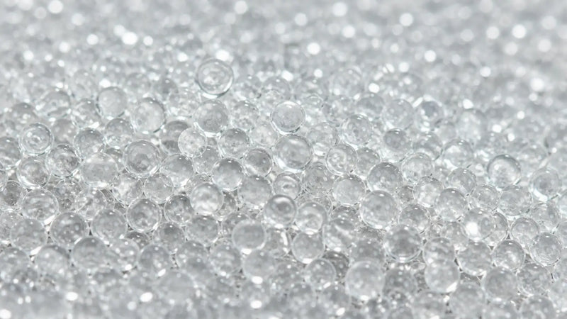 Vue macro de microbilles de verre utilisées dans le rembourrage d’une couverture lestée.