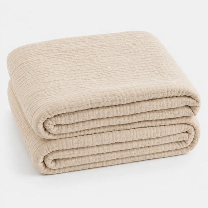 Couverture d’été Amaya beige, légère et respirante, pliée en packshot sur fond clair.