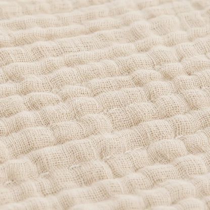 Couverture d’été Amaya beige, légère et respirante, avec détail du tissu gaufré en gros plan.