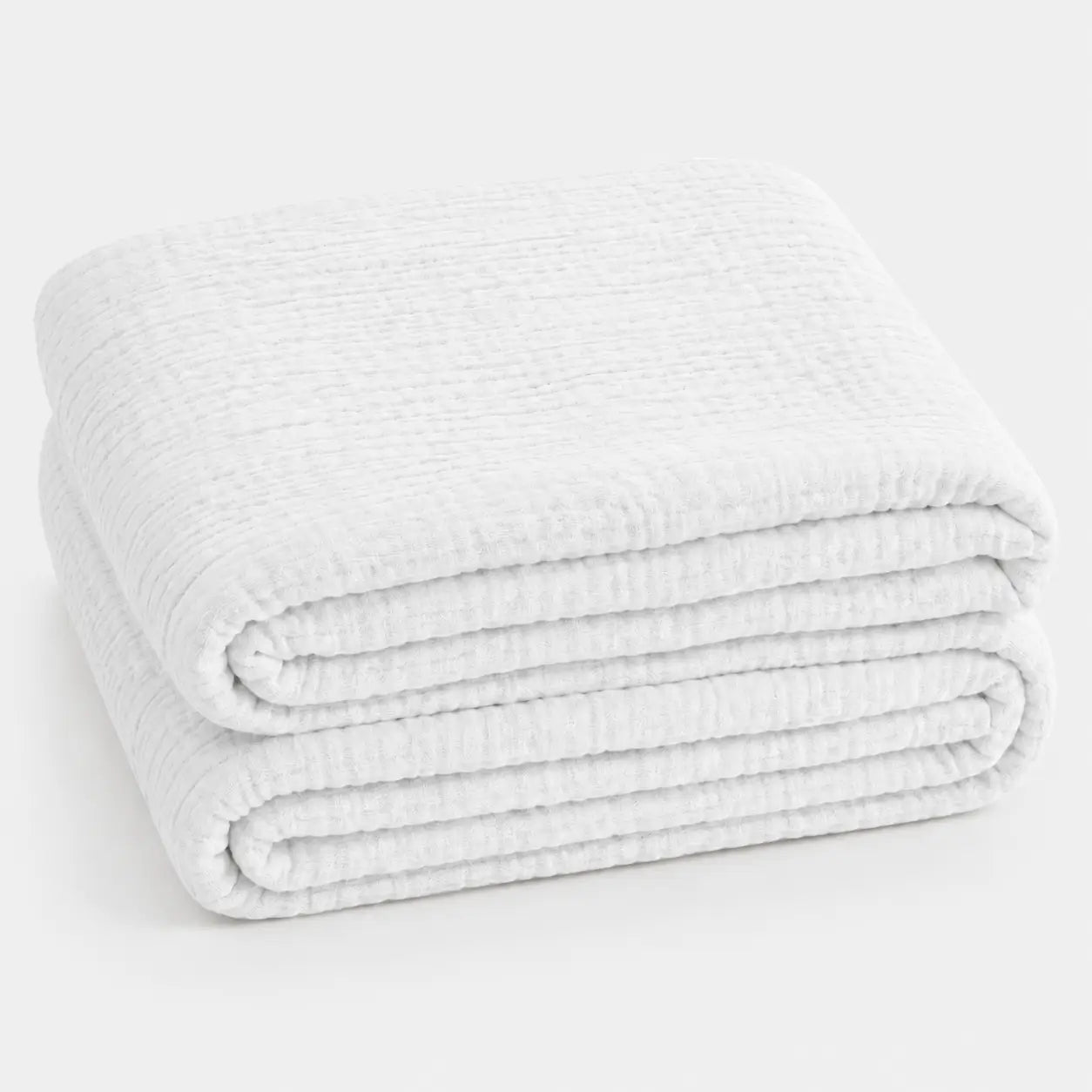 Couverture d’été Amaya blanche, légère et respirante, pliée en packshot sur fond clair.