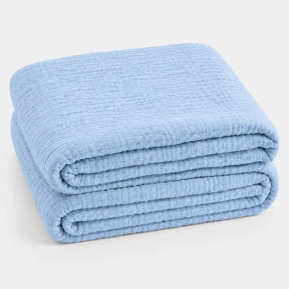 Couverture d’été Amaya bleu ciel, légère et respirante, pliée en packshot sur fond clair.