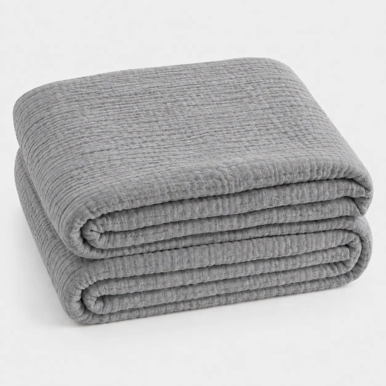 Couverture d’été Amaya gris clair, légère et respirante, pliée en packshot sur fond clair.