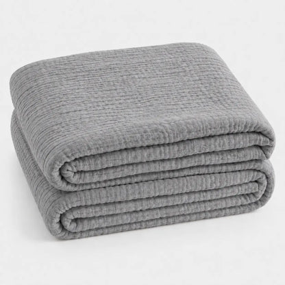 Couverture d’été Amaya gris clair, légère et respirante, pliée en packshot sur fond clair.