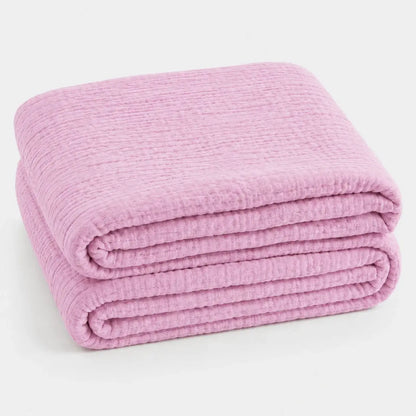 Couverture d’été Amaya rose poudré, légère et respirante, pliée en packshot sur fond clair.
