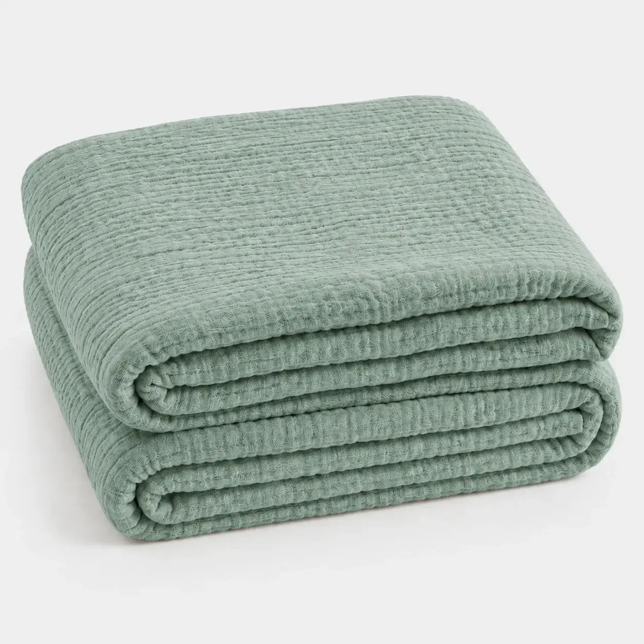Couverture d’été Amaya vert sauge, légère et respirante, pliée en packshot sur fond clair.