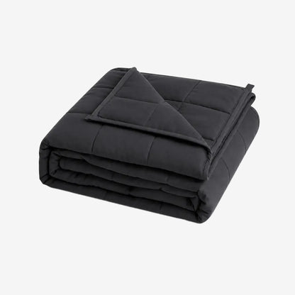 Couverture lestée graphite Cocoon Night pliée sur fond blanc.