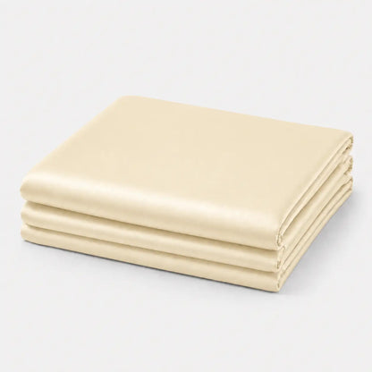 Couverture rafraîchissante en coloris crème vanille, pliée sur fond clair, avec une finition soie glacée douce et légèrement satinée.