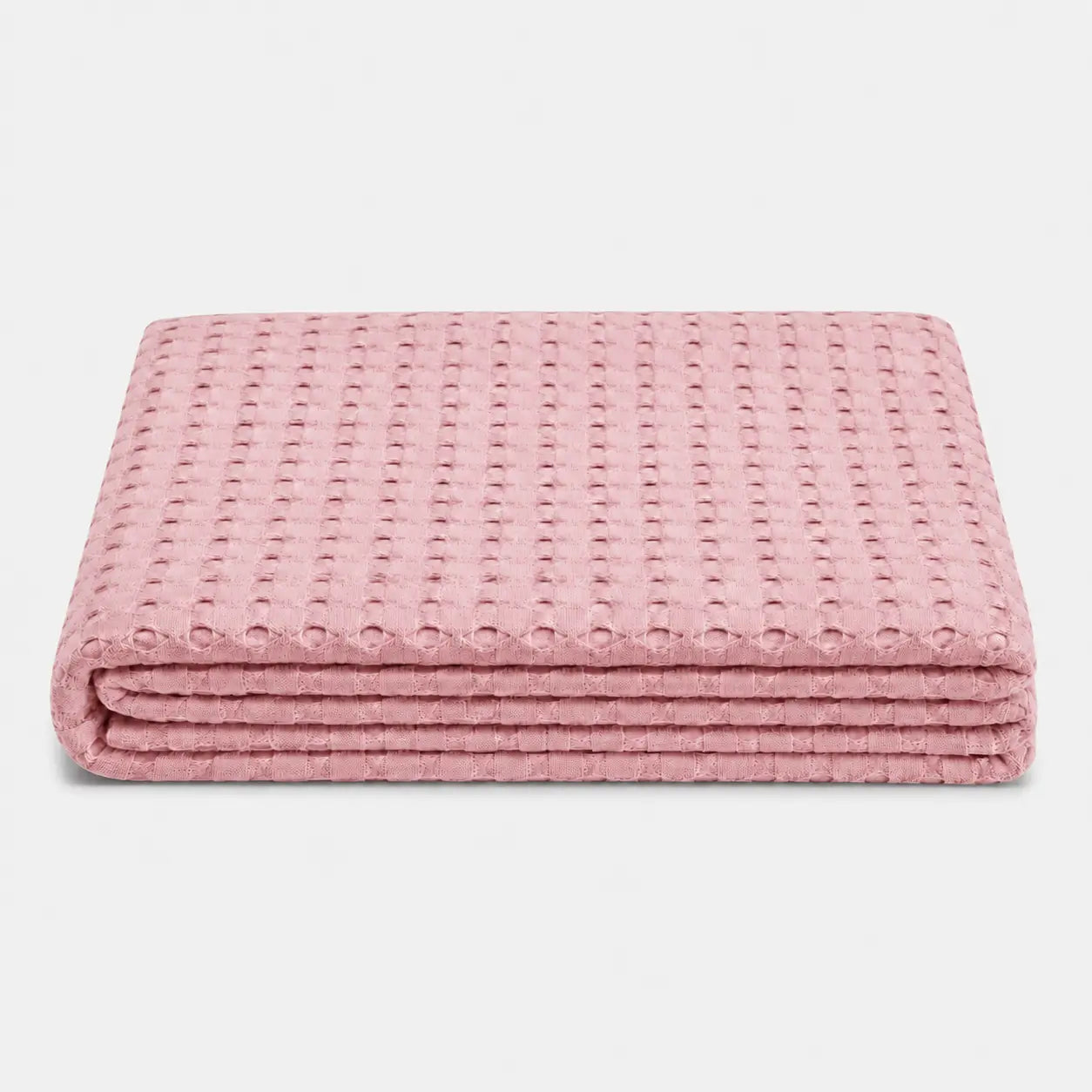 Couverture rafraîchissante Nuvia en fibre de bambou rose poudré, pliée sur fond clair avec texture gaufrée respirante et toucher doux.
