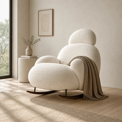 Fauteuil à bascule Nubea ivoire dans un salon Japandi minimaliste avec plaid beige et lumière naturelle chaleureuse.